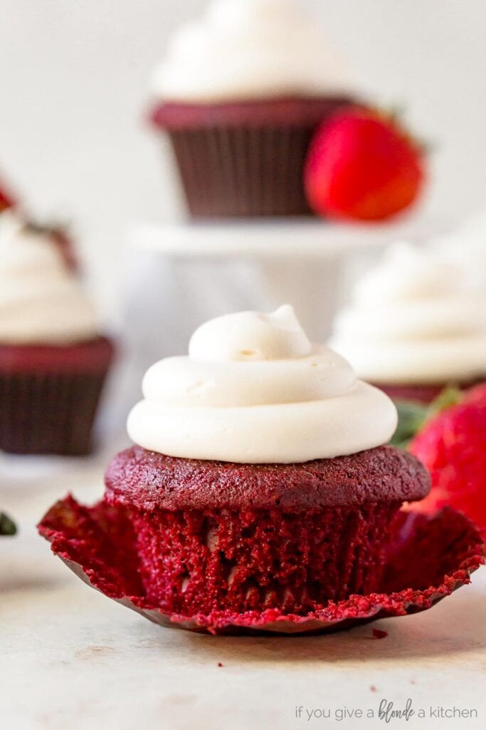 red velvet cupcake with cream cheese frosting on open paper cupcake wrapper