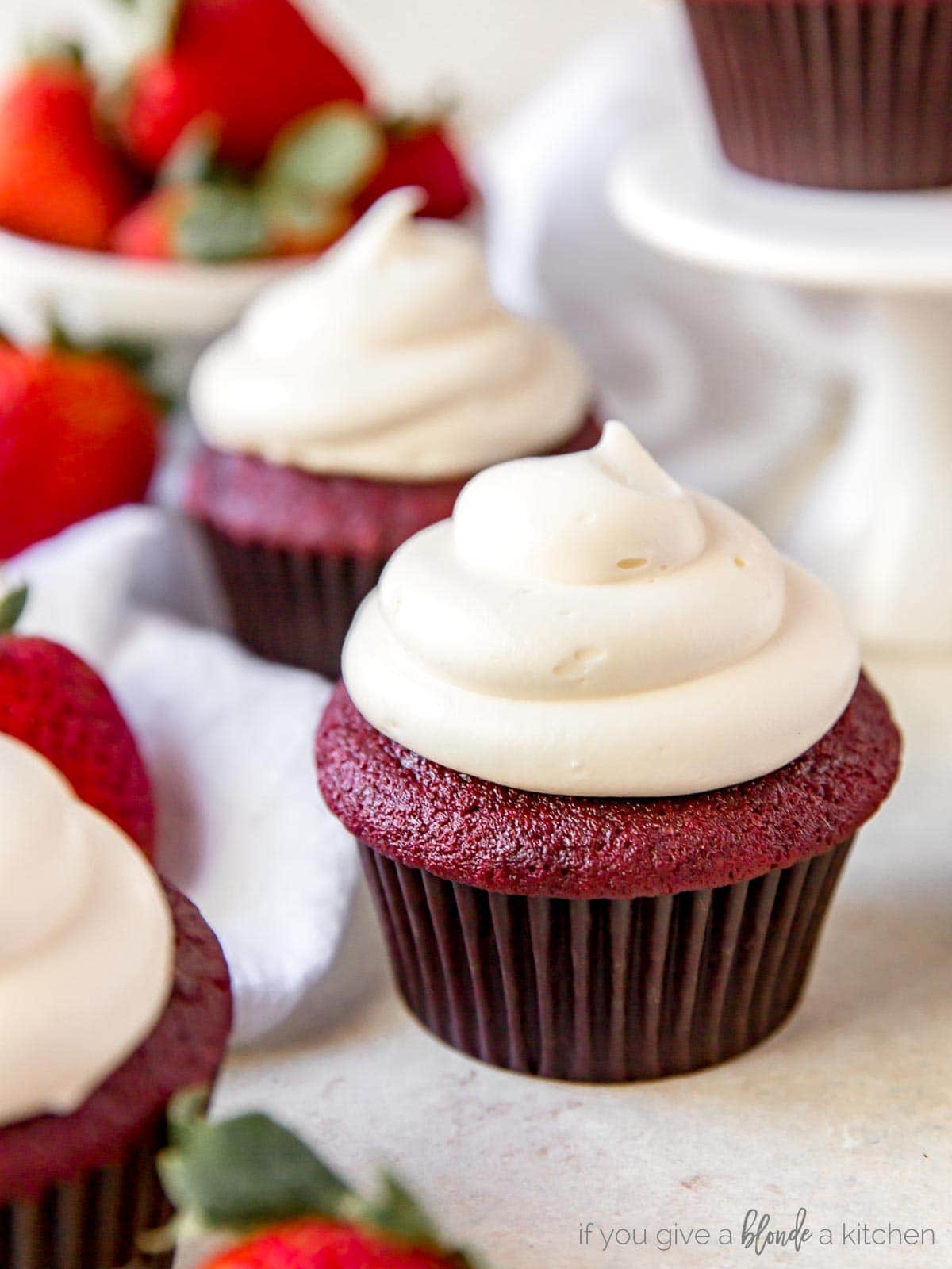 mini red velvet cupcakes lined up on profile with cream cheese frosting