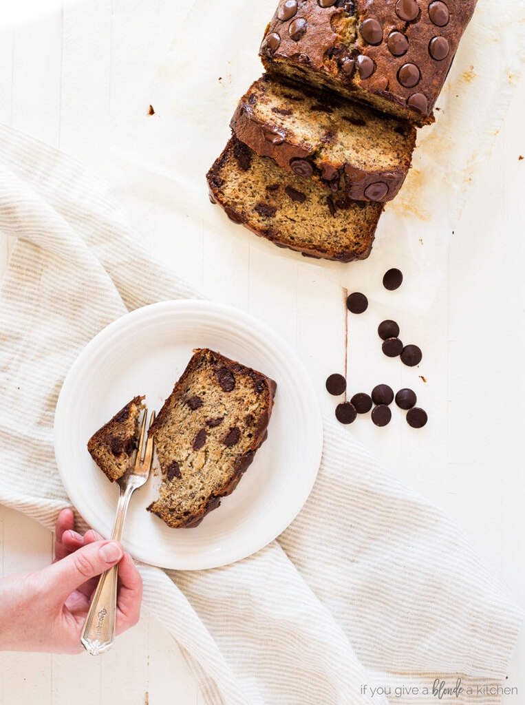 Chocolate chip banana bread recipe slice of bread on white plate, sliced loaf of banana bread with chocolate chips, white background