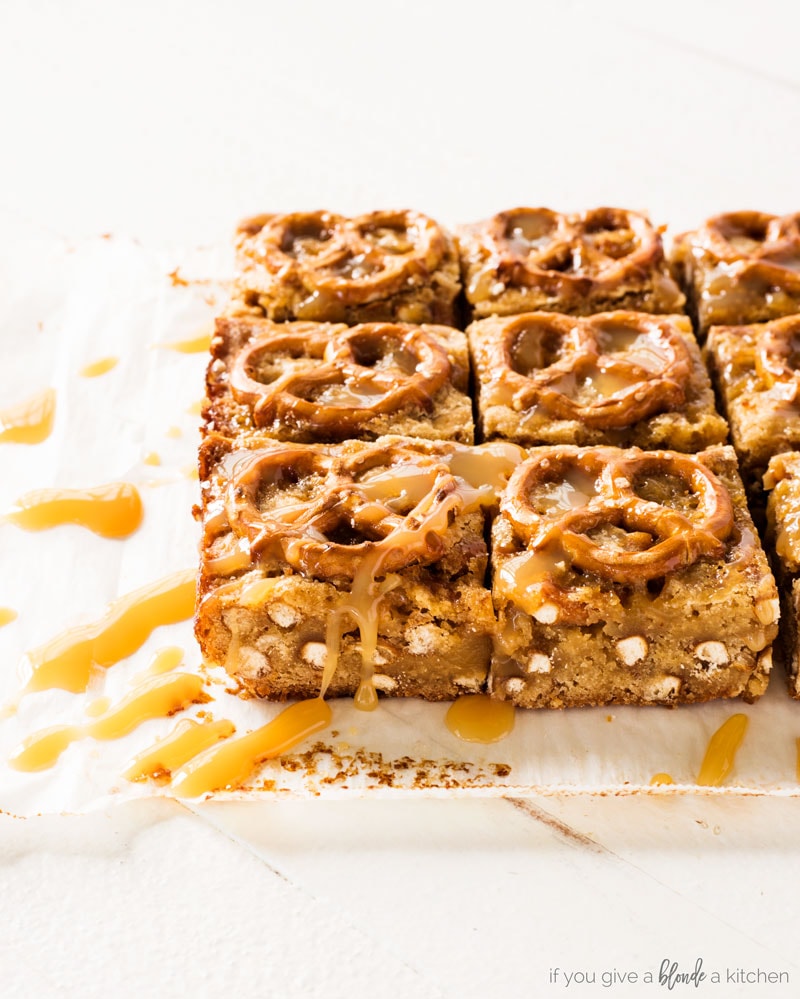 salted caramel pretzel blondies. Side view of blondies with pretzel bits and caramel drizzle