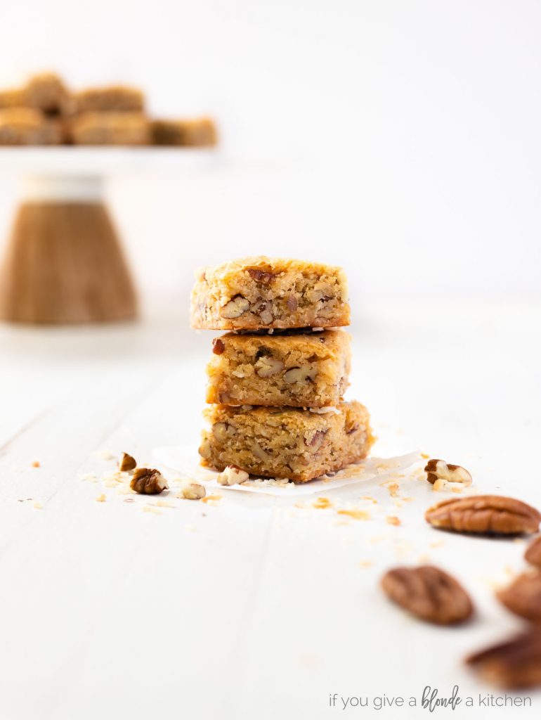 pecan coconut blondies stacked on top of each other showing center of the dessert bars. 