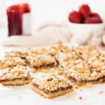 strawberry oat bars are made with almond flour in the crust and crumble. Strawberry jam is spread in the center.