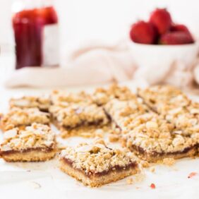 strawberry oat bars are made with almond flour in the crust and crumble. Strawberry jam is spread in the center.