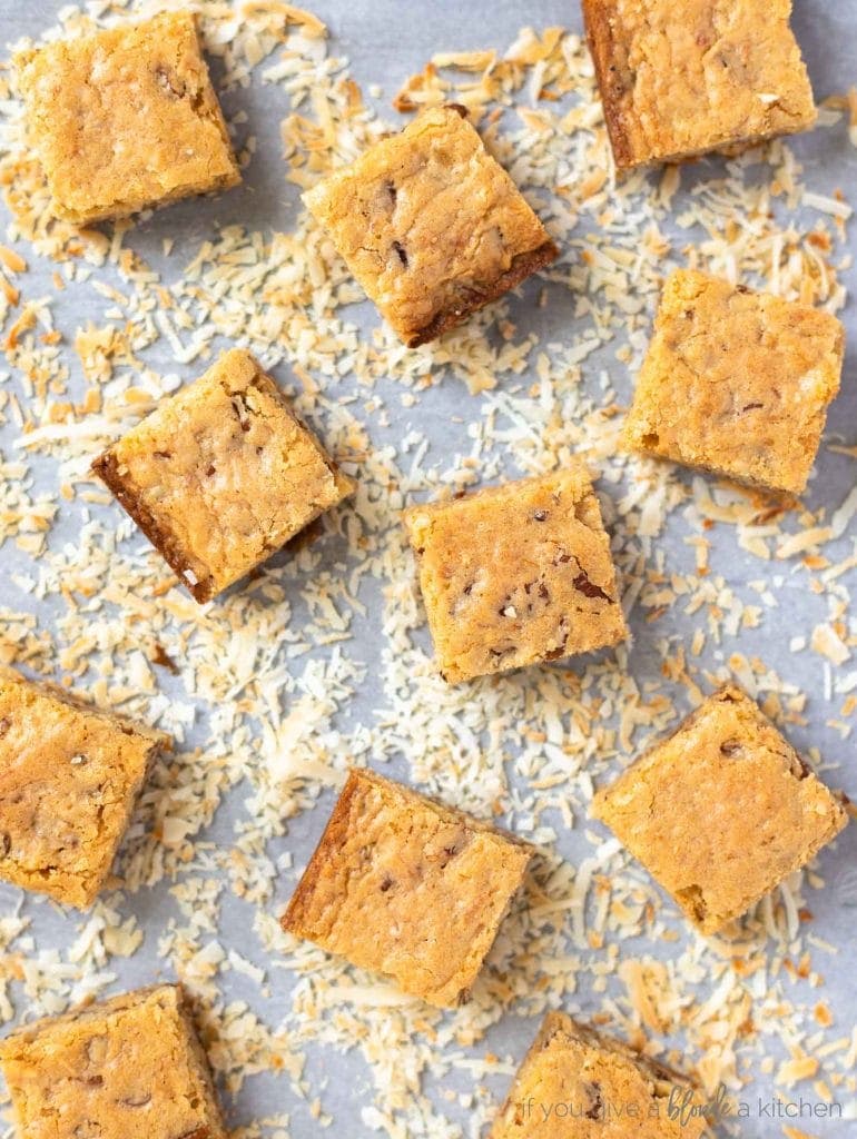 toasted coconut on cookie sheet with blondies on top cut into squares