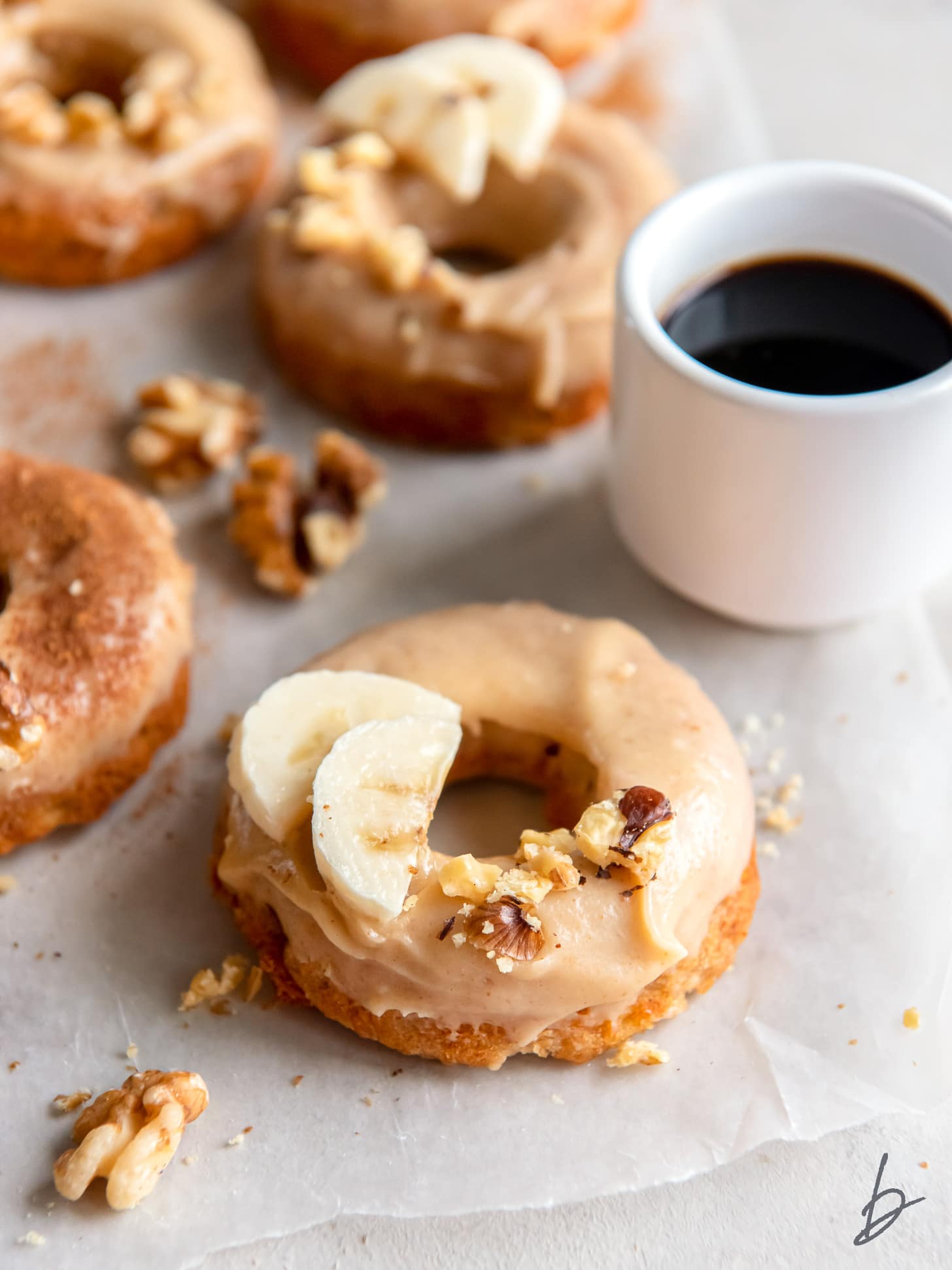 baked banana donut with brown butter glaze and fresh banana slices as garnish.