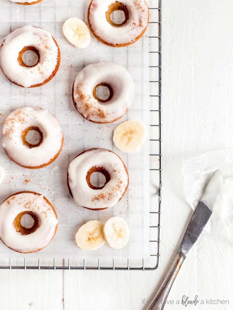brown butter banana donuts with banana slices and icing knife flat lay