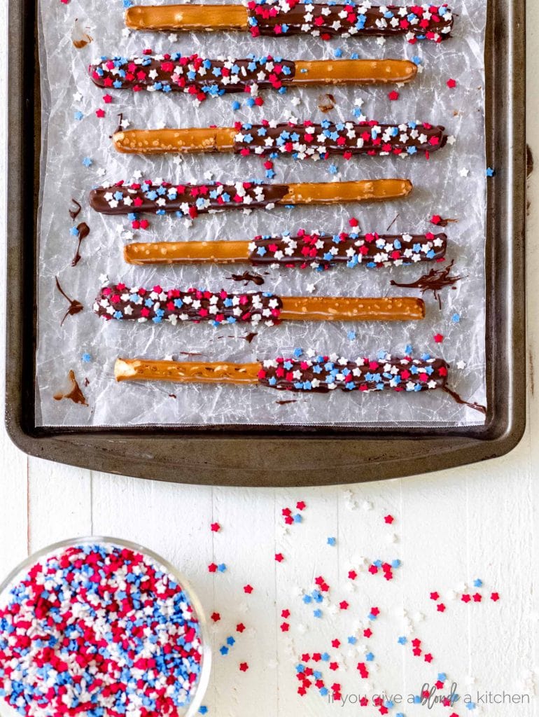 chocolate covered pretzel rods red white blue sprinkles on cookie sheet