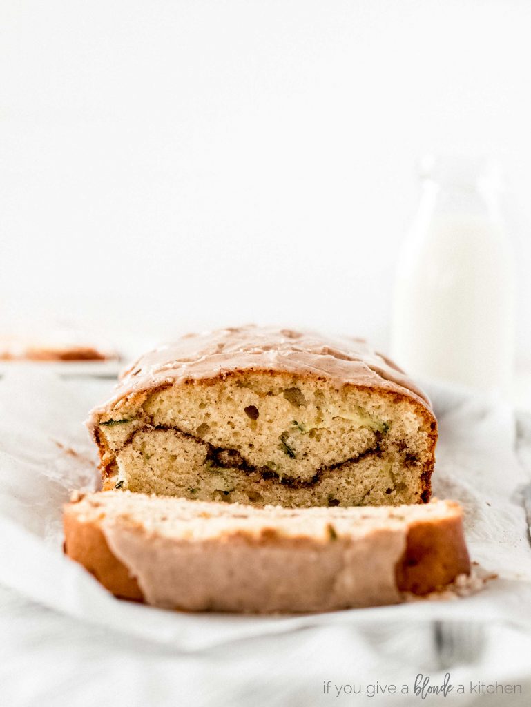 cinnamon swirl zucchini cake profile view showing cinnamon swirl. Milk bottle in the background. Light and airy photography