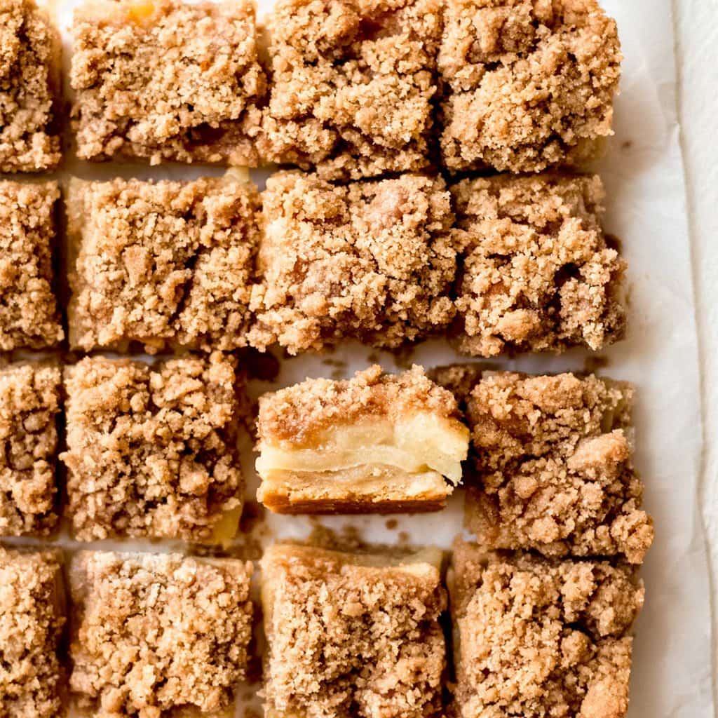 tops of apple crisp bars with one bar stood on its side to show layers of apples