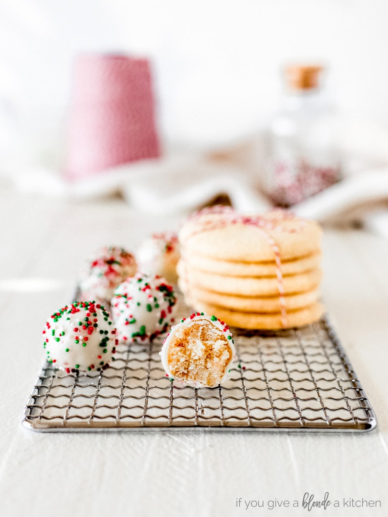 sugar cookie truffles on wire rack with stack of sugar cookies in string