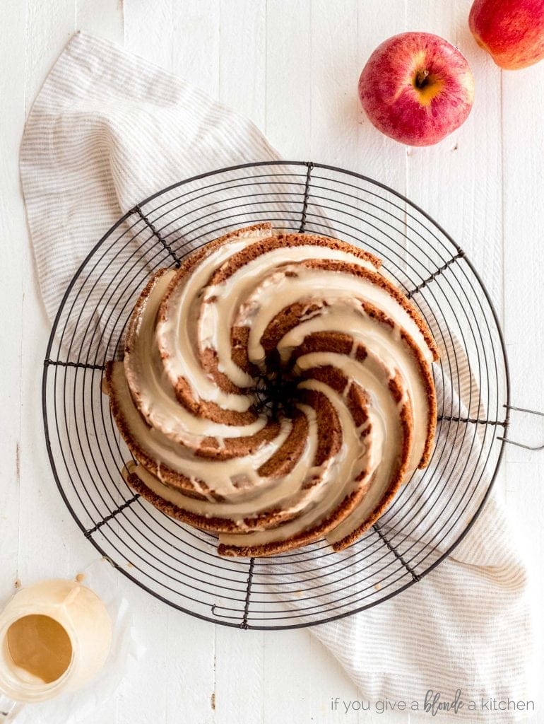 swirl apple bundt cake with glaze on round wire cooling rack