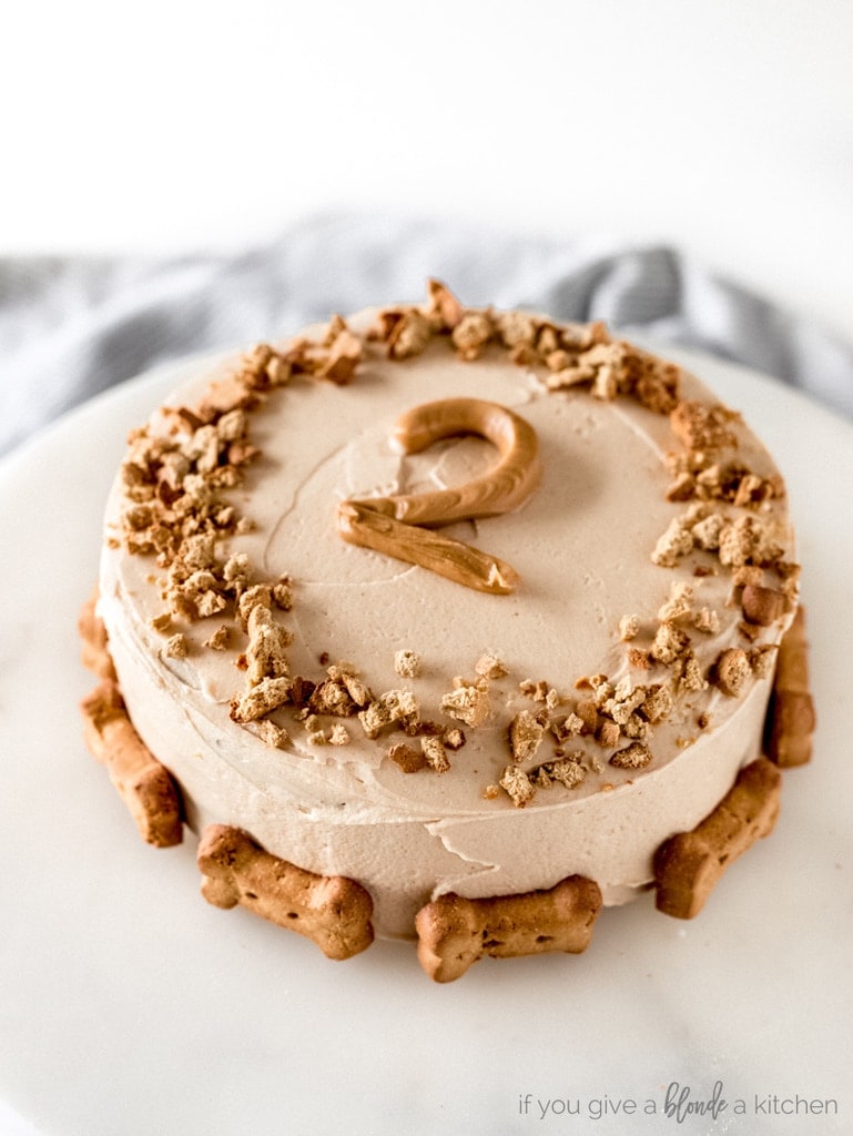 pumpkin dog cake with yogurt frosting and a peanut butter piped 2 and dog biscuit decorations