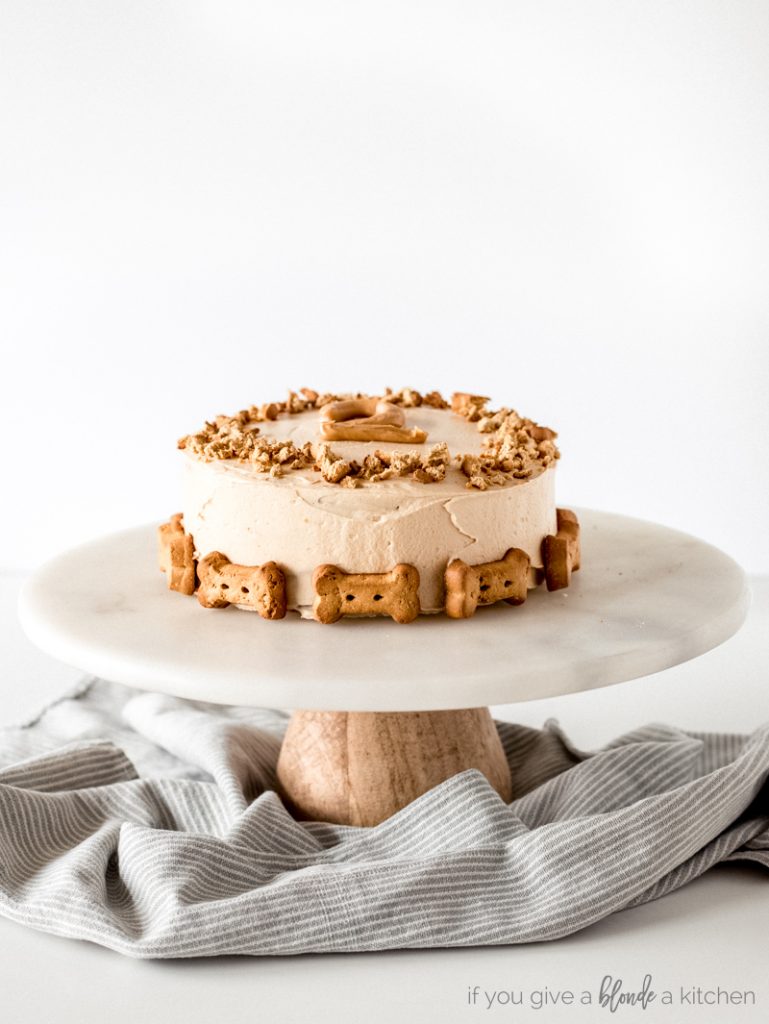 pumpkin dog cake decorate with biscuits on a cake stand