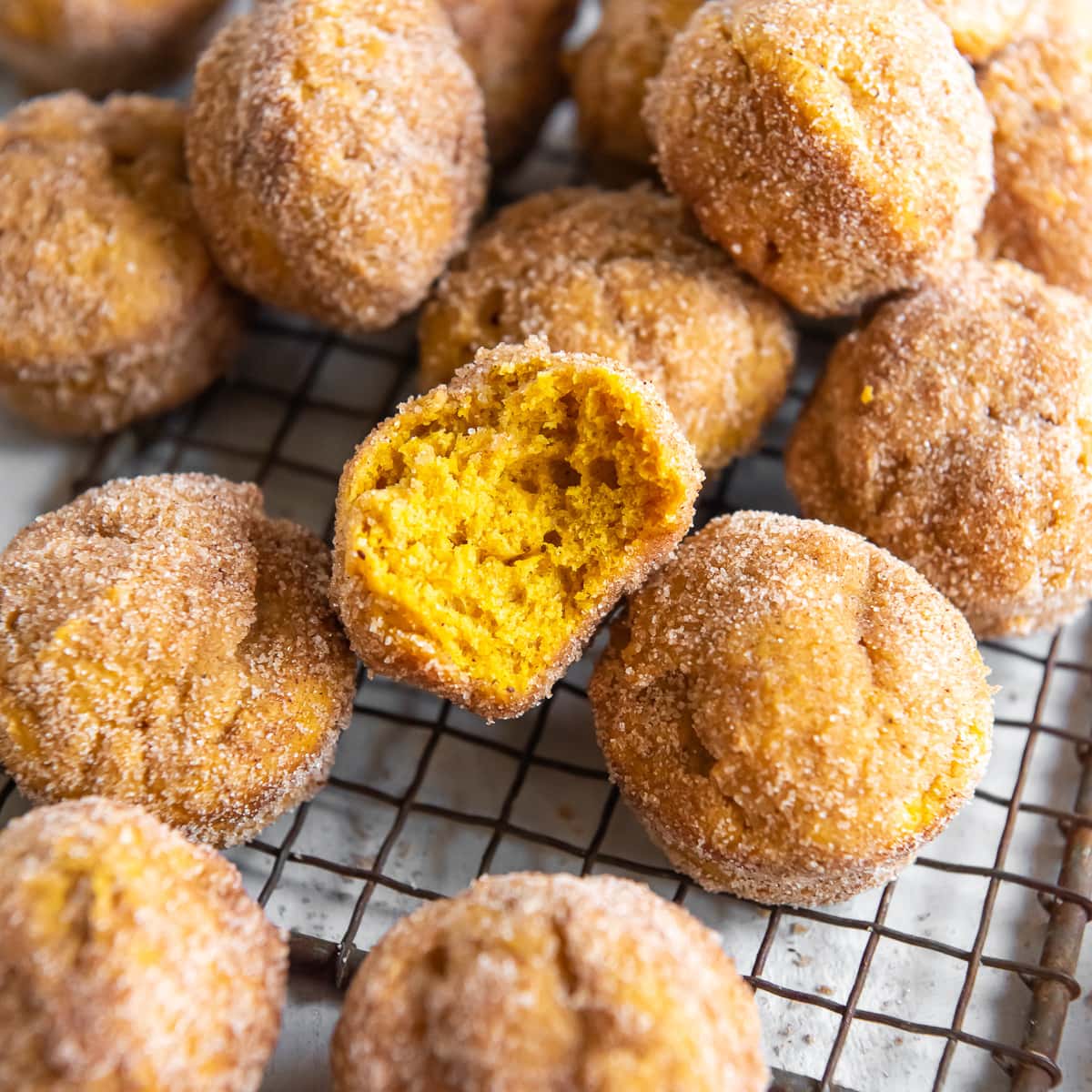 cinnamon sugar pumpkin donut holes on wire rack.
