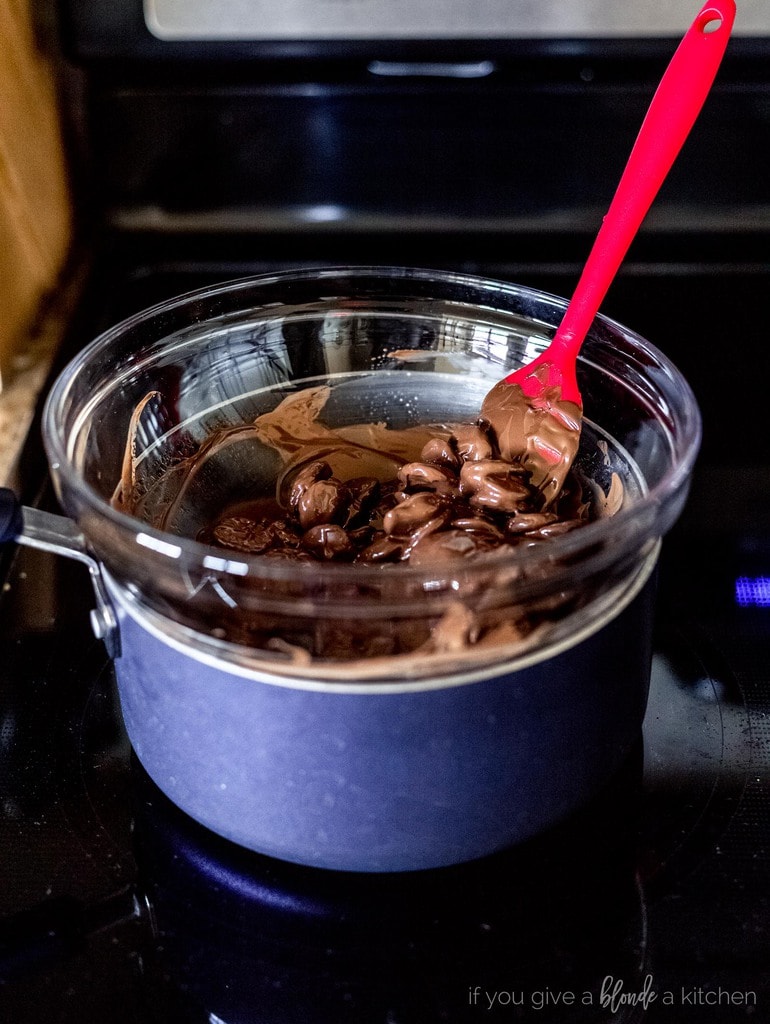 dark chocolate melting in makeshift double boiler glass bowl.