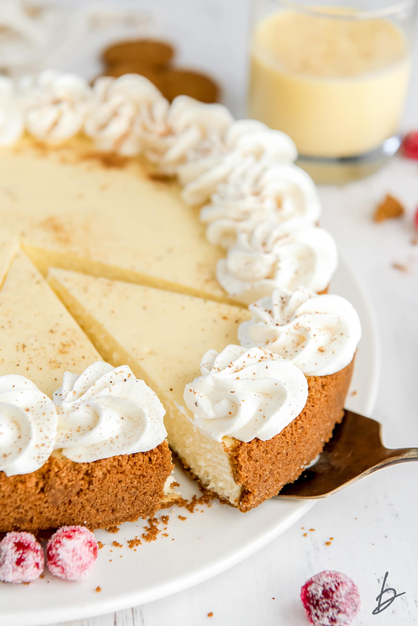 cake server taking slice of eggnog cheesecake from plate.