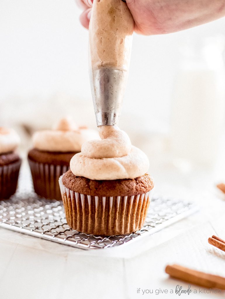 cream cheese frosting piped onto gingerbread cupcakes