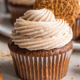 gingerbread cupcake topped with cinnamon cream cheese frosting and cookie garnish.