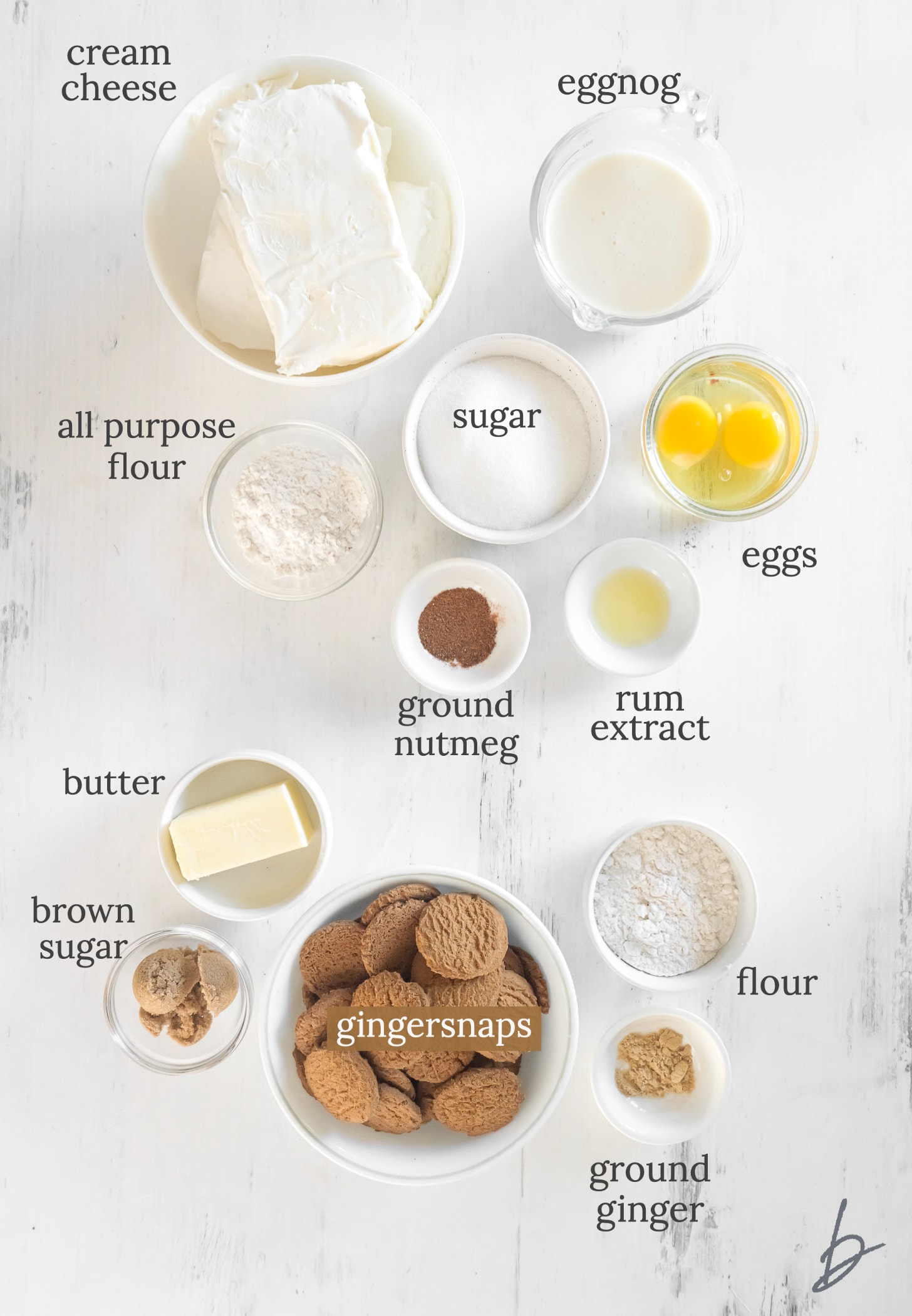 eggnog cheesecake ingredients in bowls labeled with text.