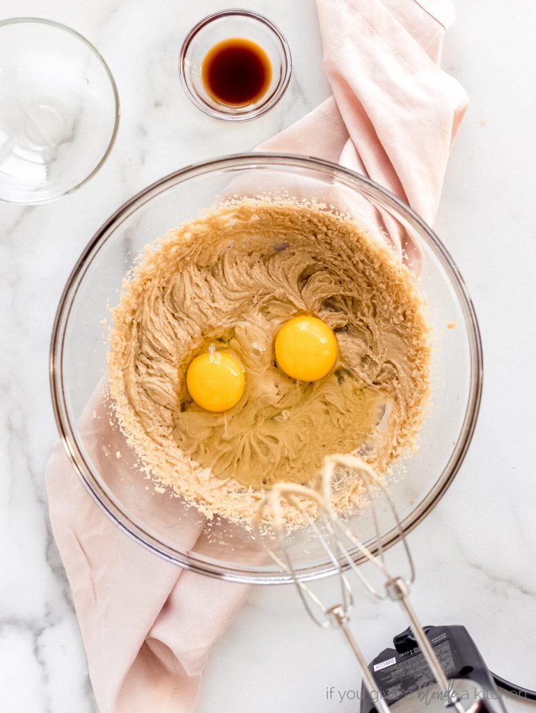 two eggs in bowl of brown sugar and butter mixture