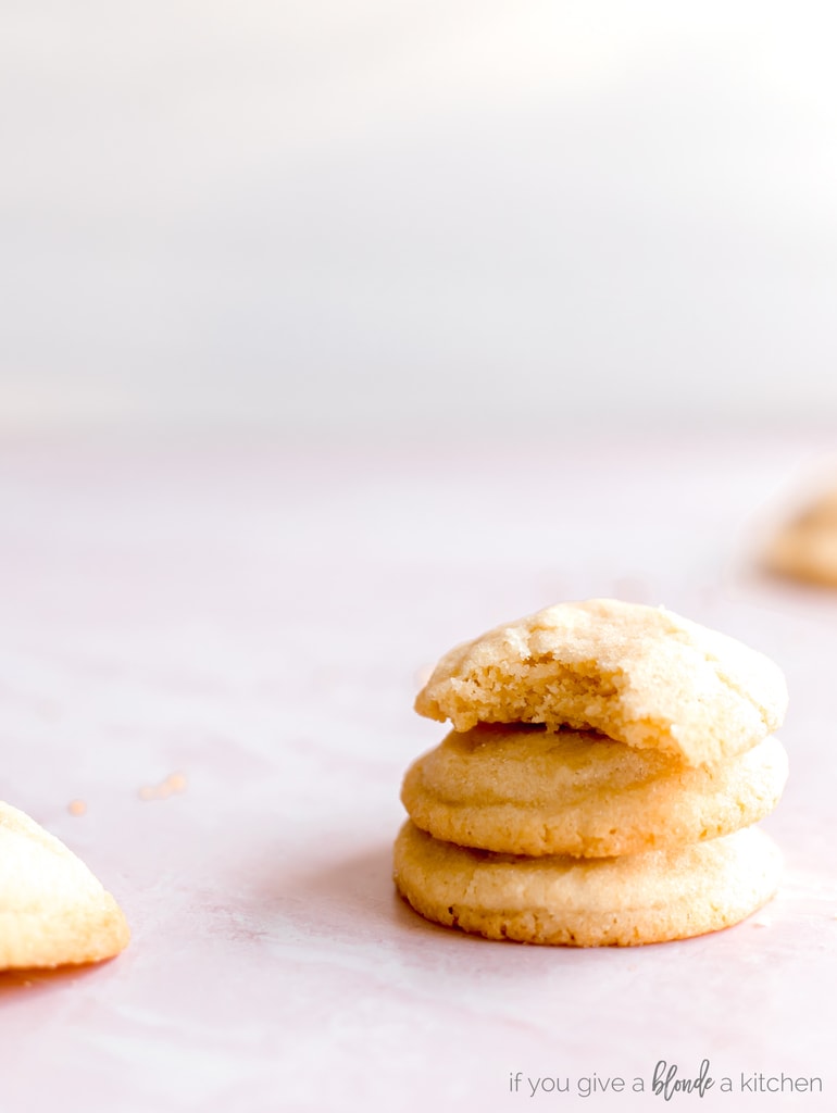 stack of three sugar cookies, top cookie with bite