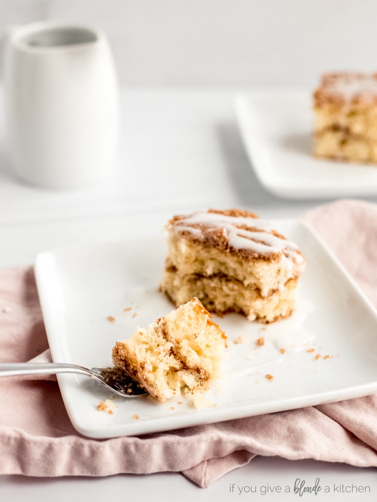 coffee cake square on plate. Fork holding bite of coffee cake