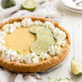 graham cracker crust key lime pit with whipped cream florets and lime slices