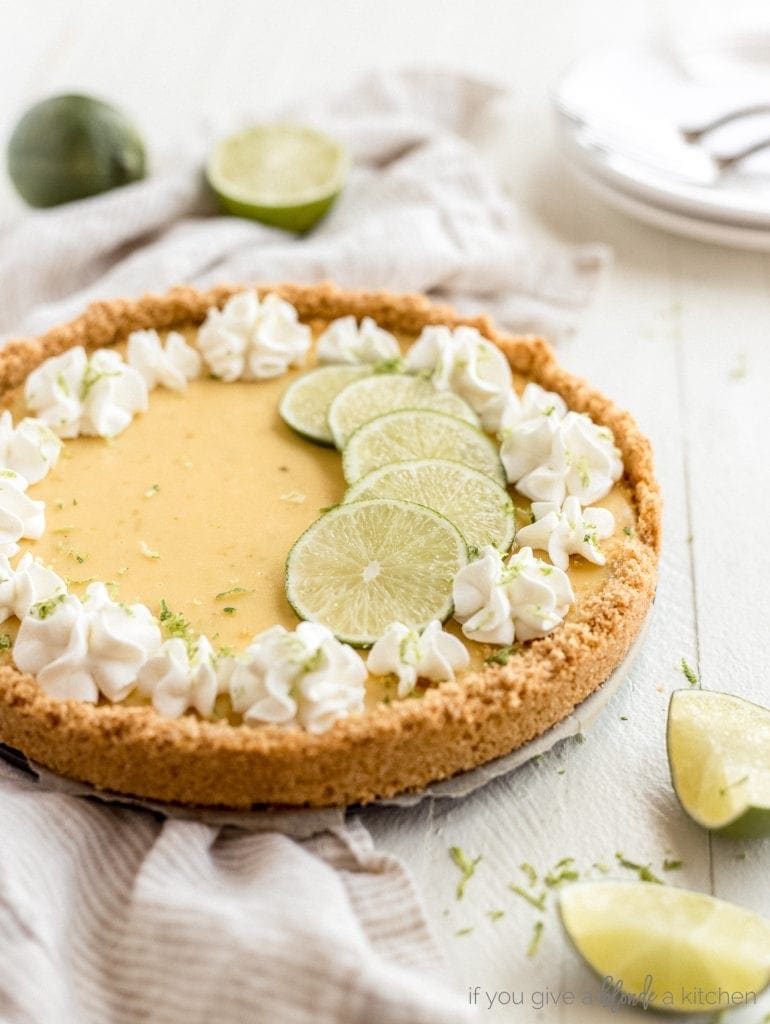 graham cracker crust key lime pit with whipped cream florets and lime slices