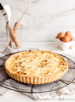 quiche lorraine on round wire cooling rack on countertop