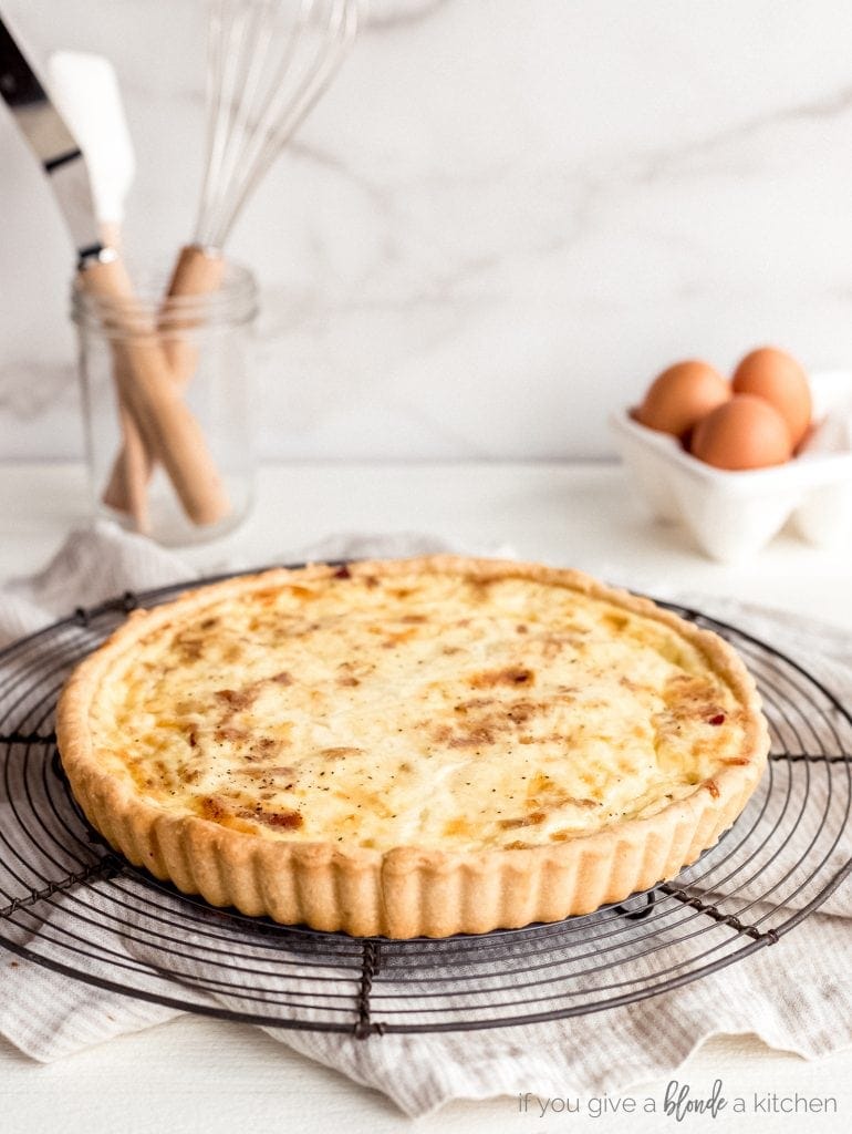 quiche lorraine on round wire cooling rack on countertop