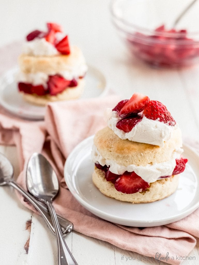 two strawberry shortcakes on white round plates