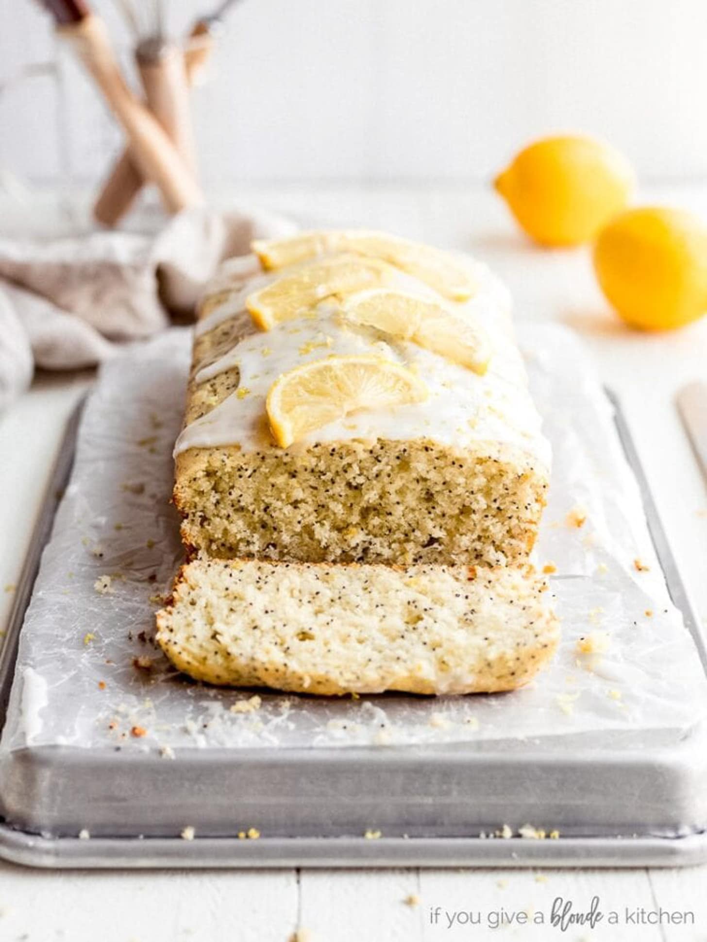 lemon poppyseed bread on parchment paper and baking sheet. end cut off showing inside of loaf.