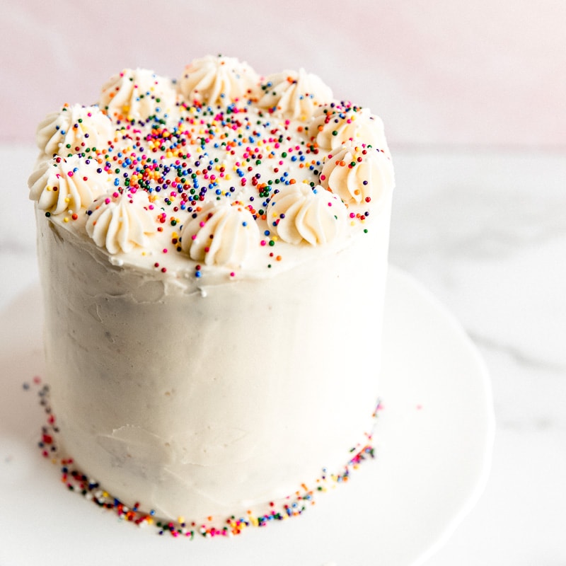 vanilla frosted layer cake with rainbow nonpareils