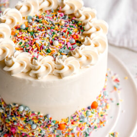 homemade funfetti cake frosted with buttercream and decorated with rainbow sprinkles.
