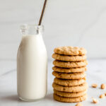 glass bottle of milk next to stack of peanut butter cookies