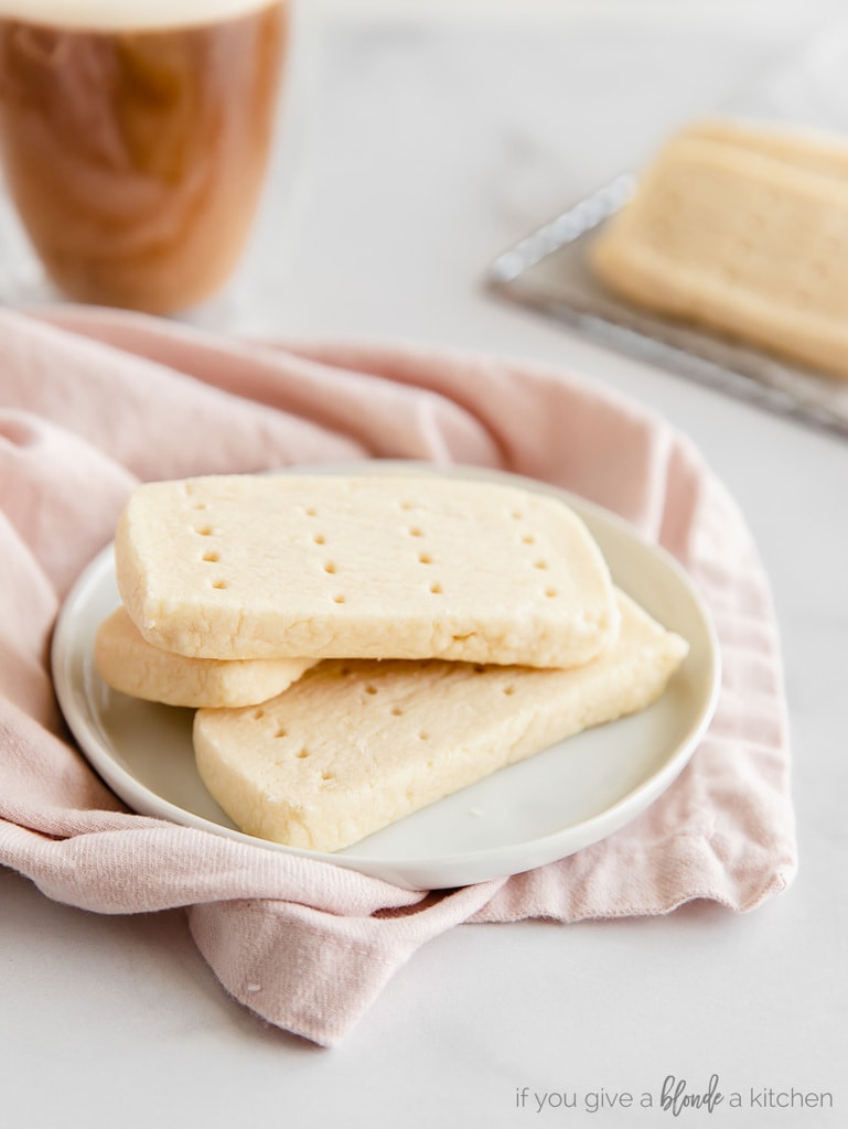 three rectangle shortbread cookies on white round plate; plate on pink kitchen towel