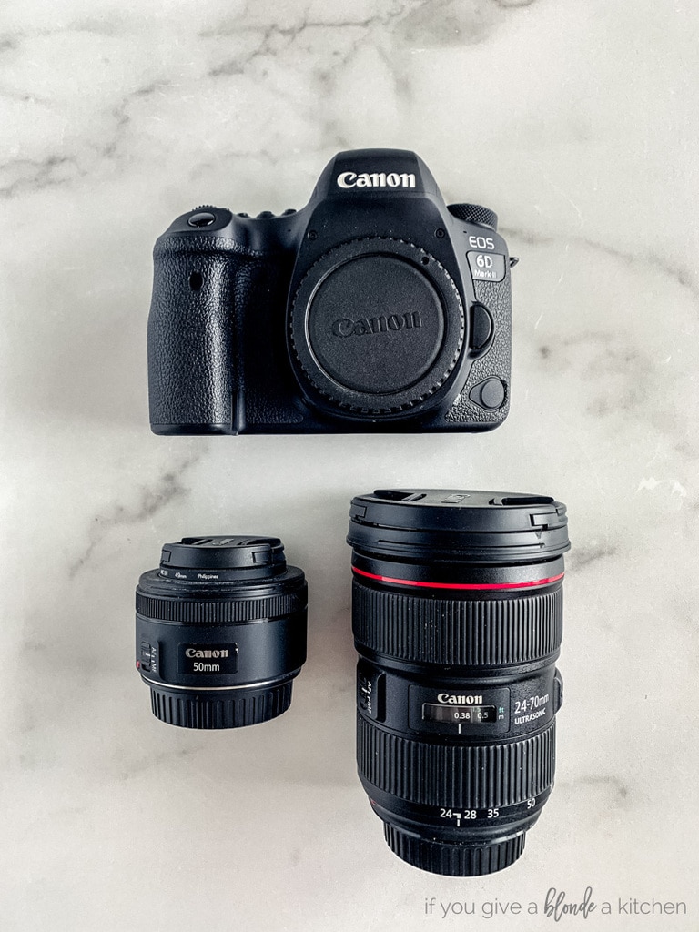 canon camera and two lenses on marble surface