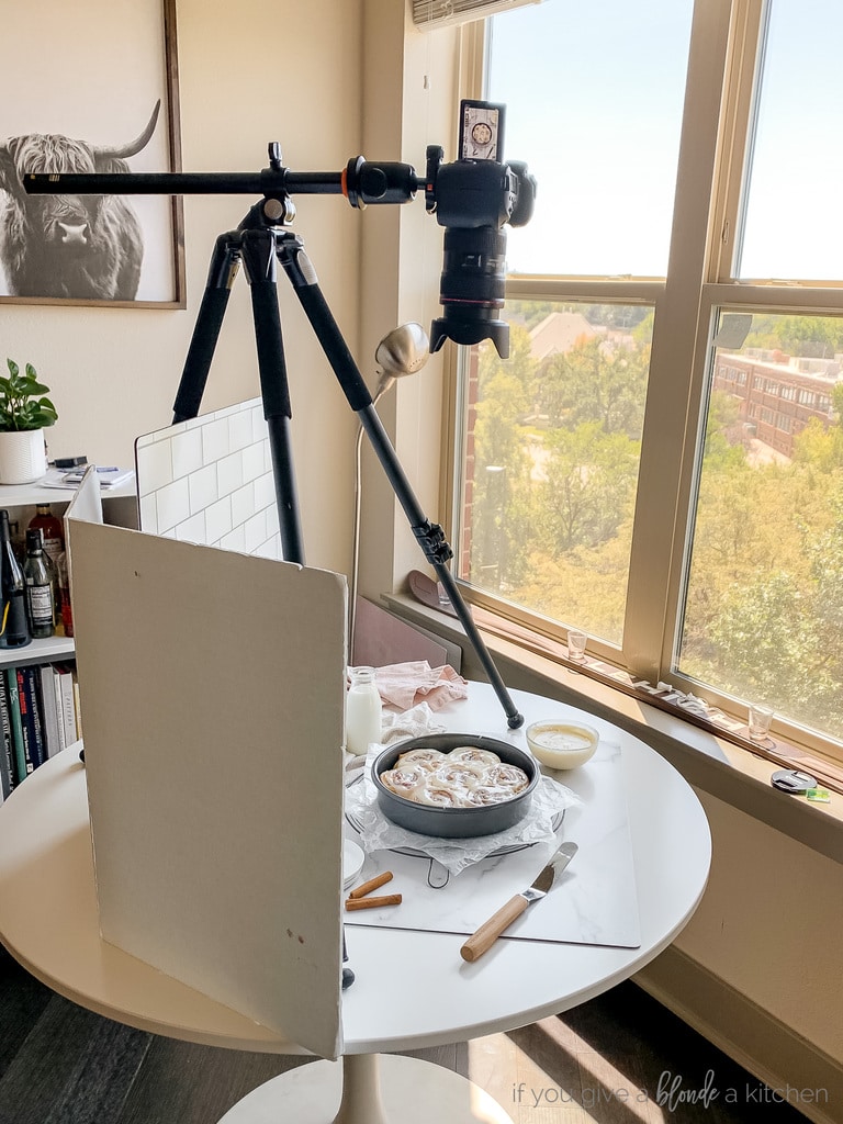 photography set up tripod on white table with camera angled down at food on table