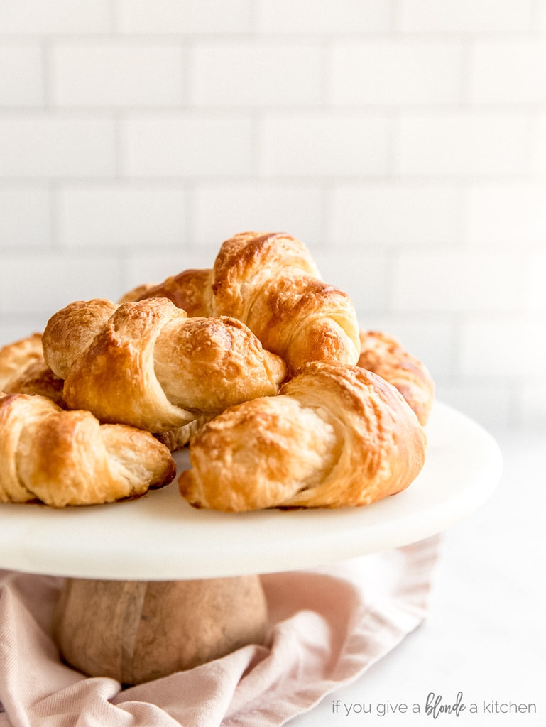 homemade croissants on bake stand; subway tile in the background