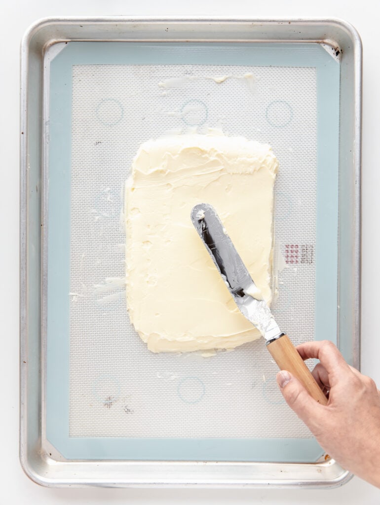 offset spatula spreading butter into a rectangle on silpat