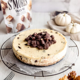 cheesecake topped with chopped chocolate; cheesecake on round wire cooling rack