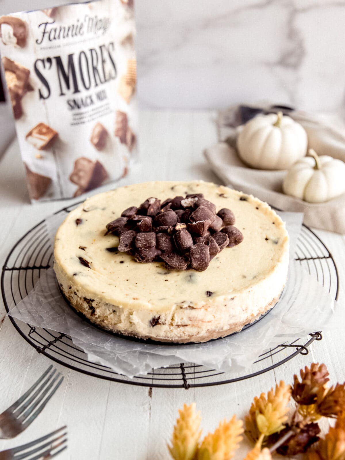 cheesecake topped with chopped chocolate; cheesecake on round wire cooling rack