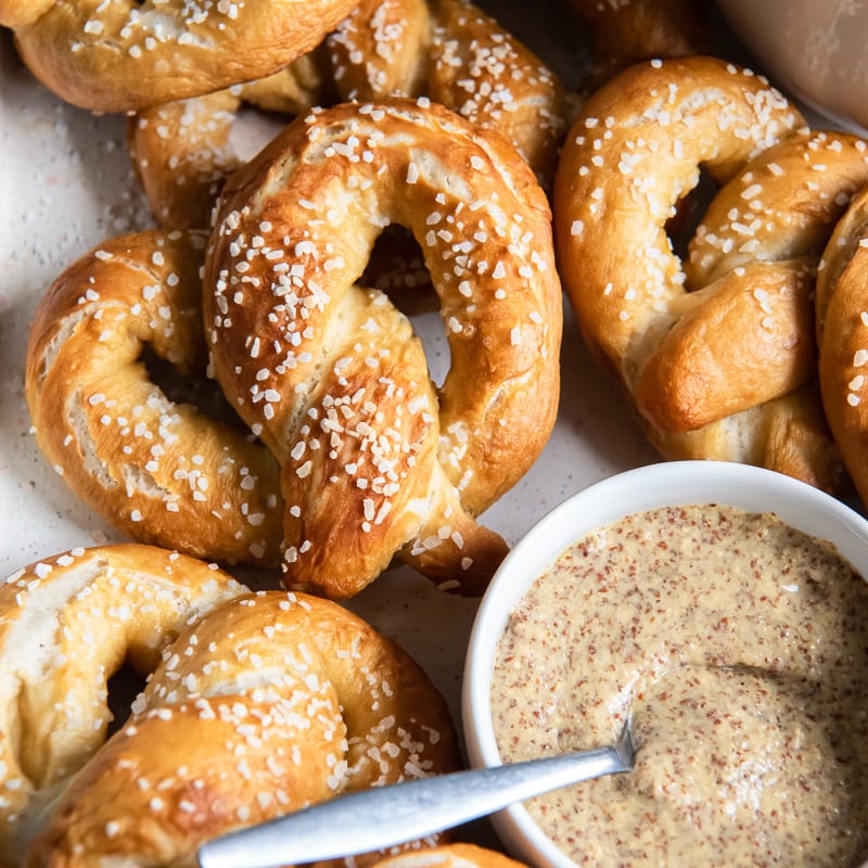soft pretzels on next to small bowl of mustard with spoon.