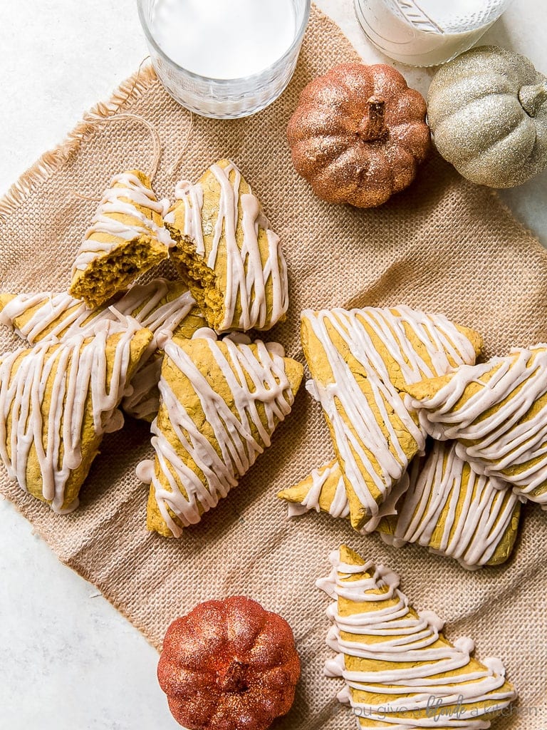 pumpkin scones with a glaze on burlap; glittery pumpkin decorations next to scones