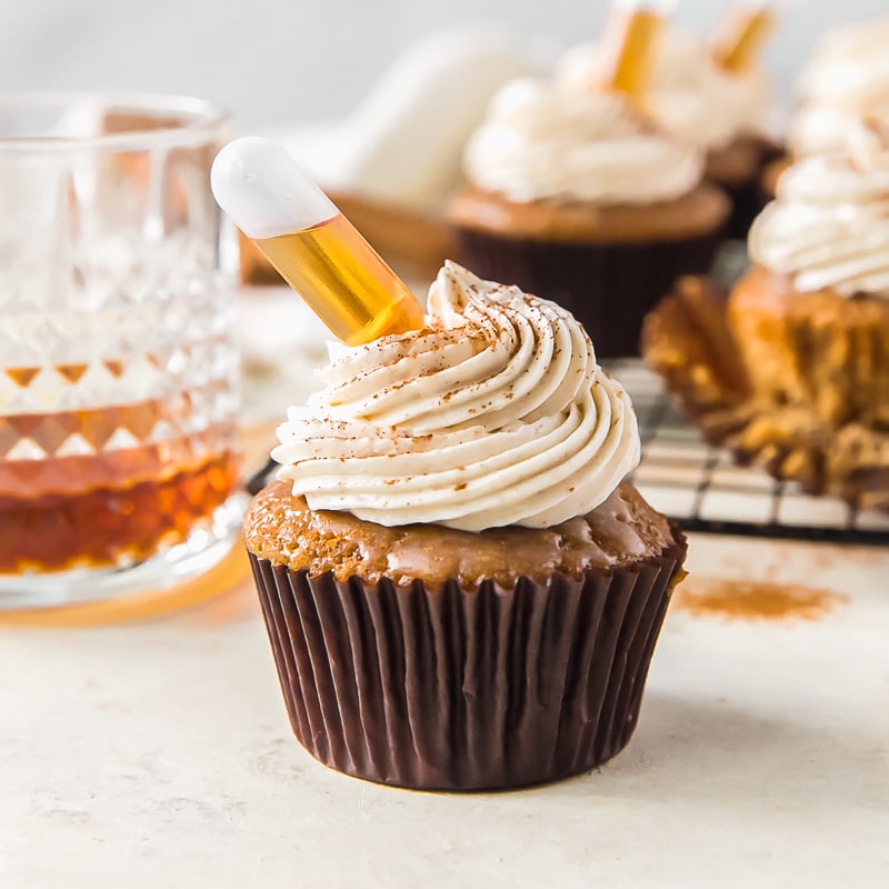 rum cupcake topped with butter glaze, cinnamon frosting and a rum injection tube