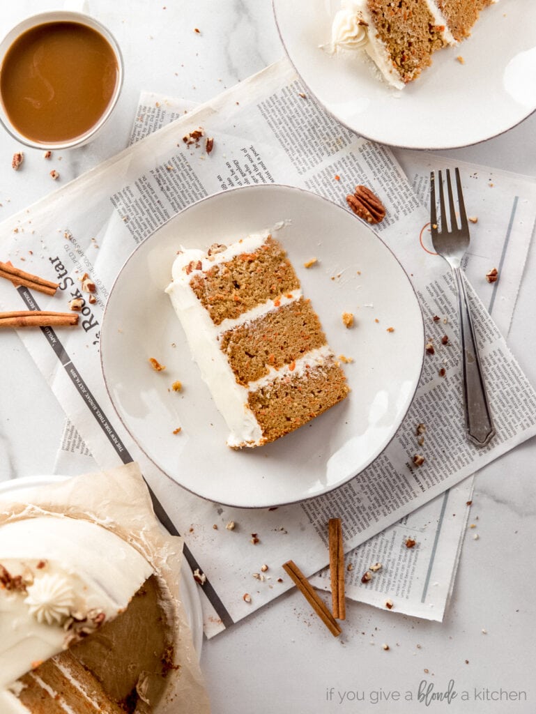 slice of triple layer carrot cake with cream cheese frosting on a plate