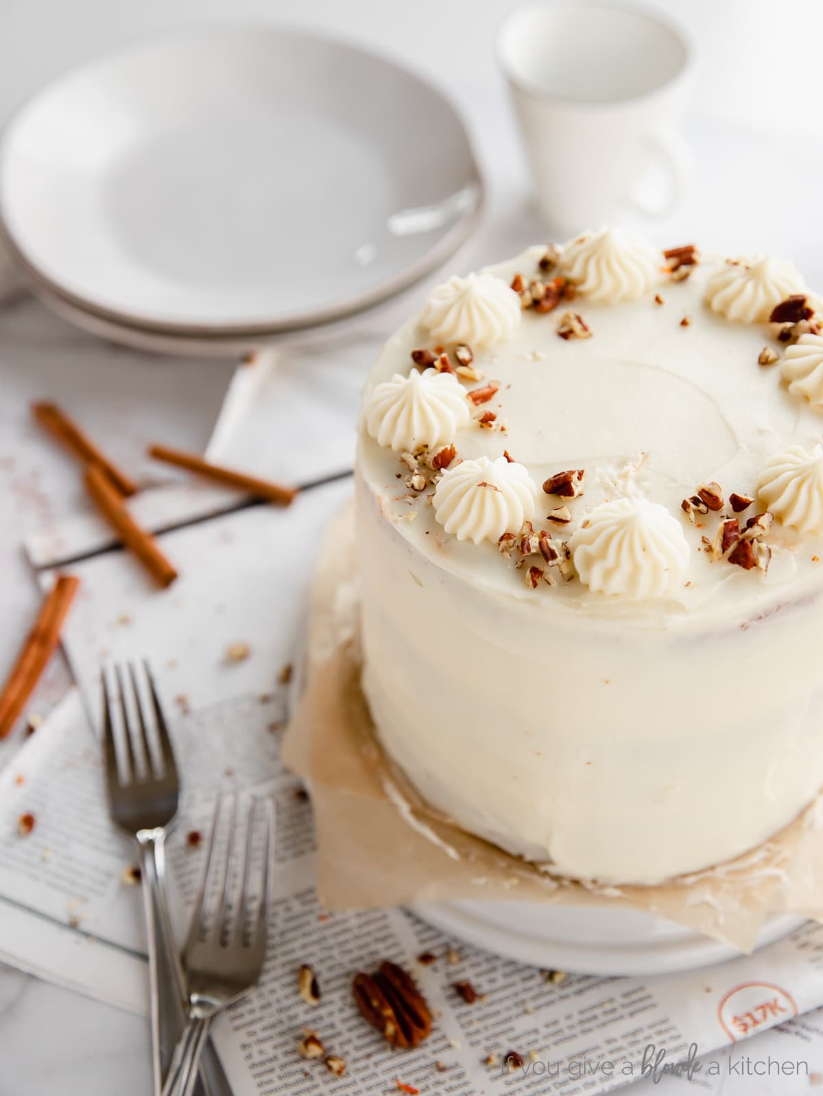 carrot cake frosted with cream cheese frosting; crushed pecans sprinkled on top of cake
