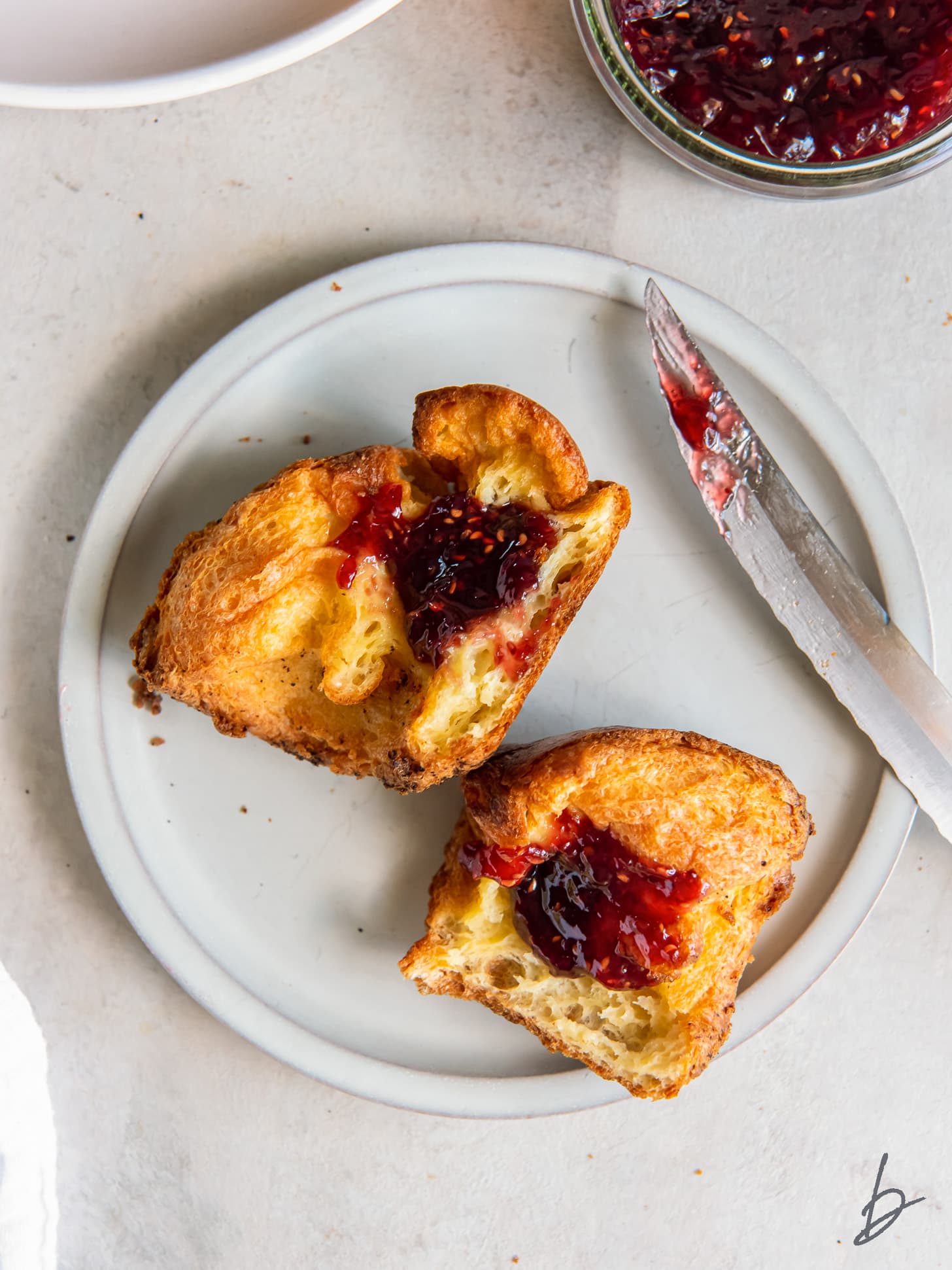 popover on a plate with jam spread inside.