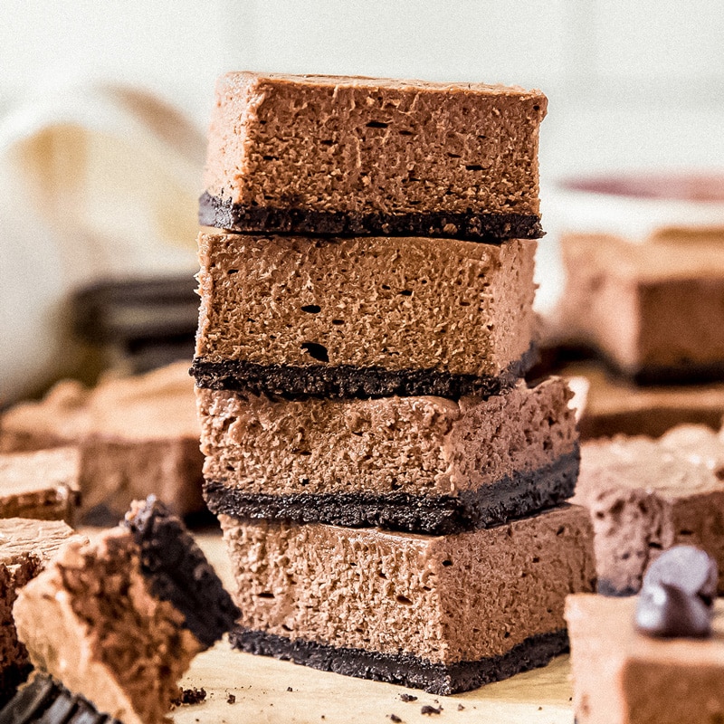stack of four chocolate cheesecake bars with oreo crust.