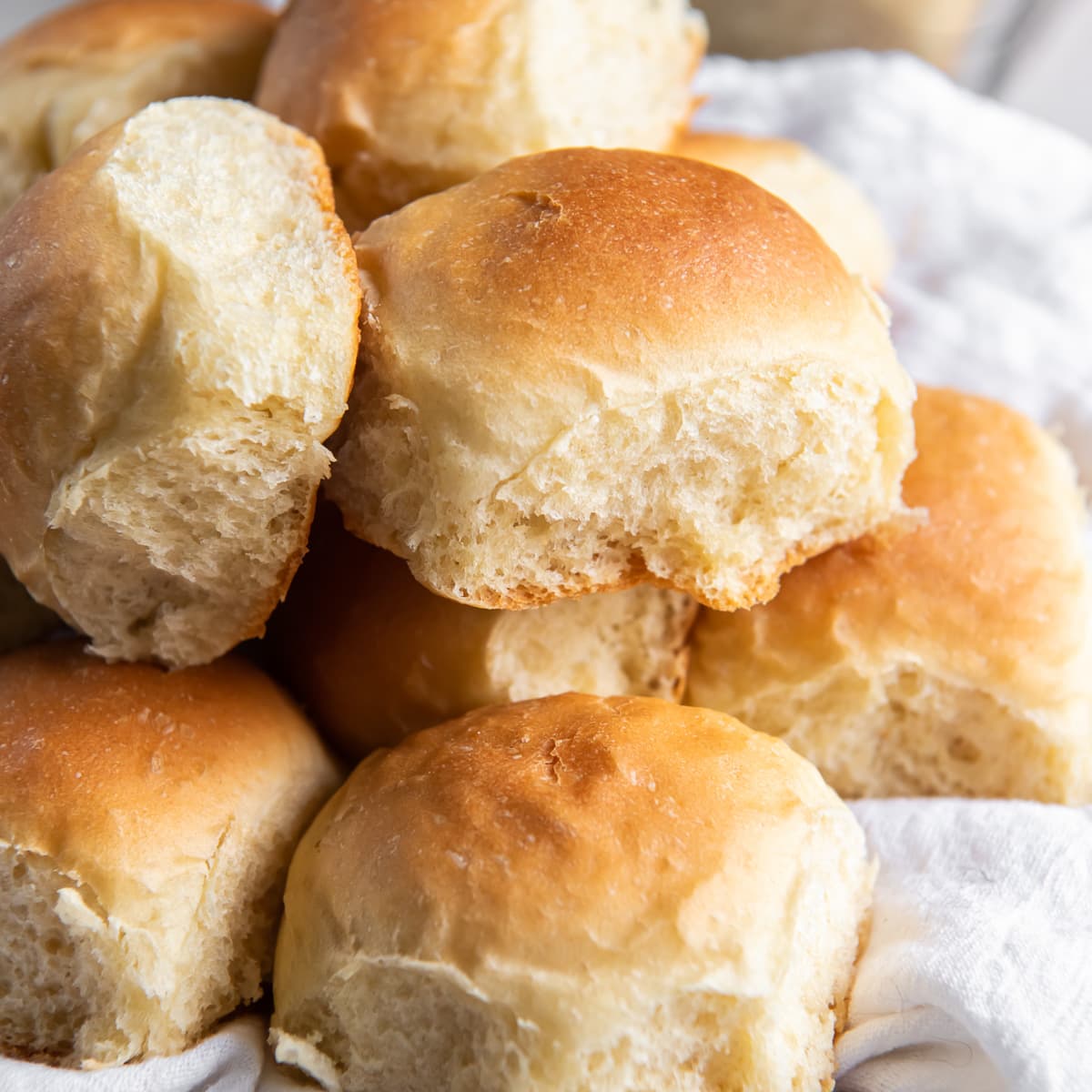 soft golden dinner roll on top of more rolls.